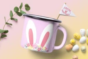 A pink coffee mug illustrated with a bunny face, as well as leaves and Easter eggs surrounding it.