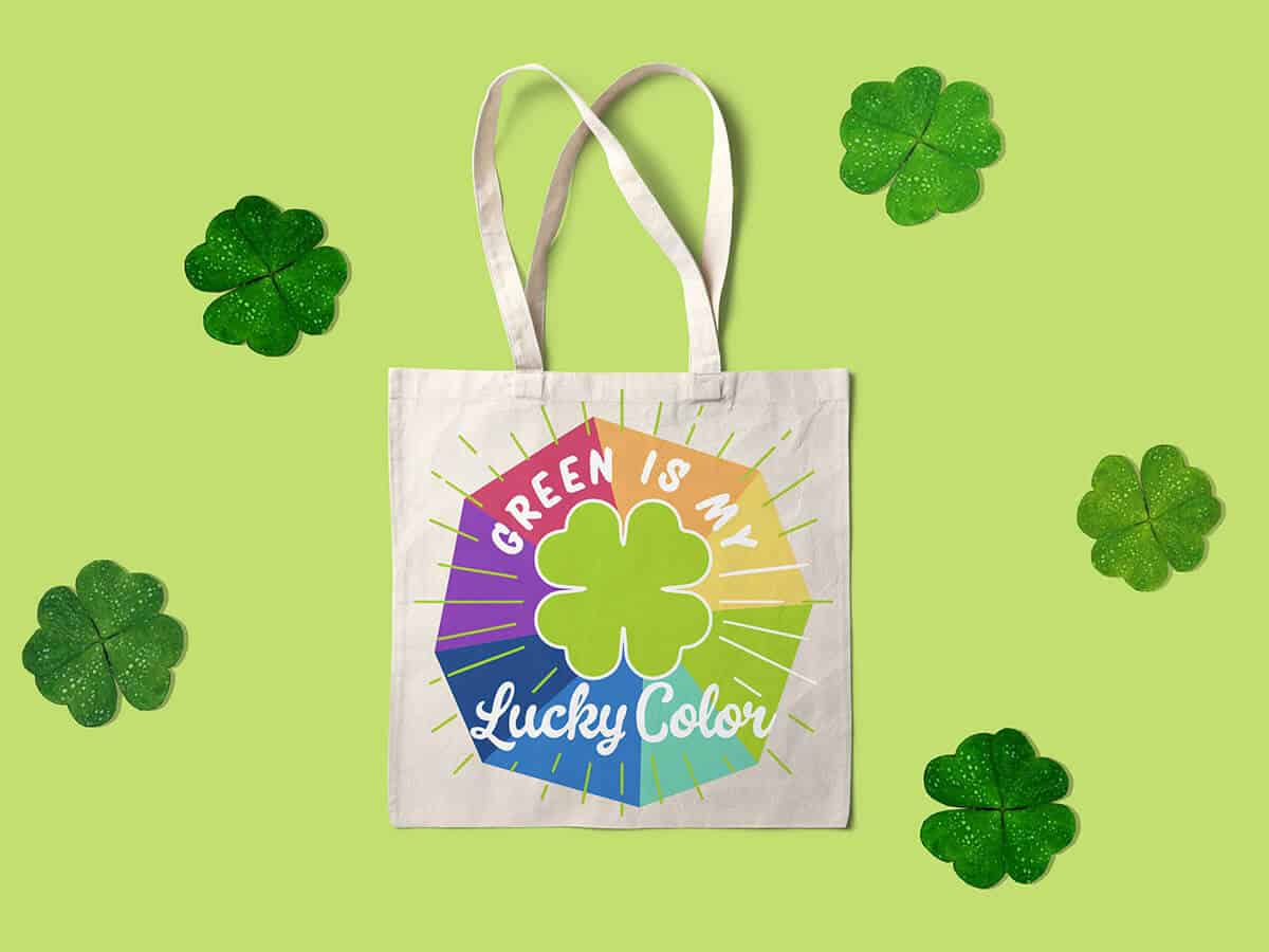 A tote bag with "green is my lucky color" written on a rainbow shape illustration