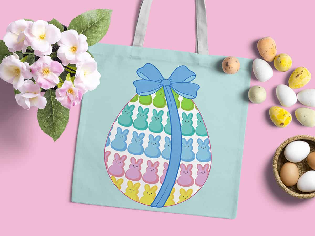 Top view of a bag with an easter egg illustration surrounded by eggs and flowers on a light pink background