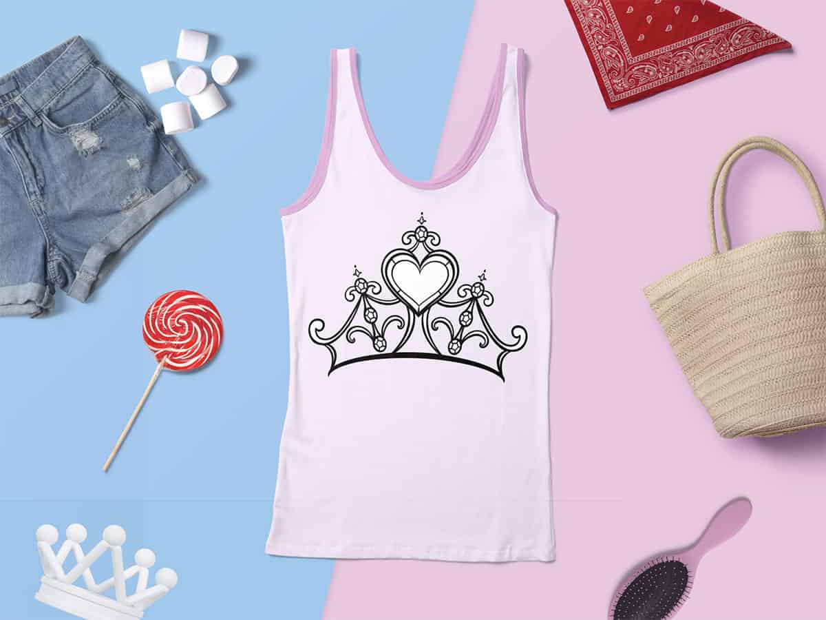 White tank top with black heart and crown design, paired with denim shorts, a lollipop, straw tote bag, and pink hairbrush on a split blue and pink background.